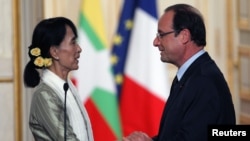 Myanmar pro-democracy leader Aung San Suu Kyi shakes hands with French President Francois Hollande as they attend their joint news conference at the Elysee Palace in Paris on June 26.