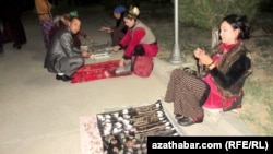 Women sell jewelry at a night market in Mary Province's Bayramaly district.