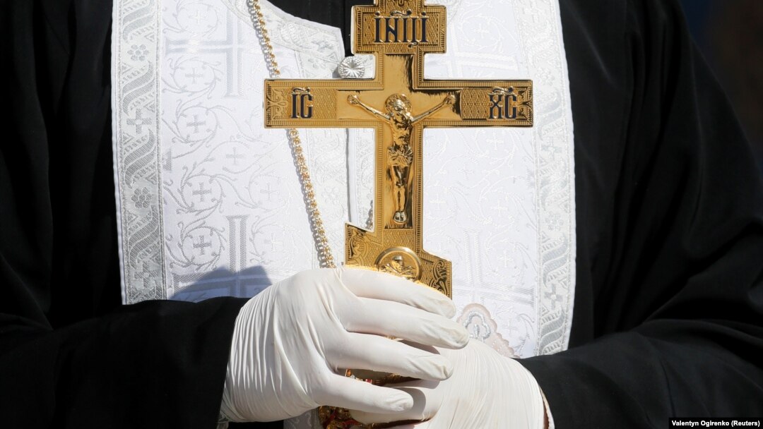 An Orthodox clergyman in Ukraine wears protective gloves, as a preventive measure against the coronavirus during a ceremony to bless Easter cakes earlier this week. 