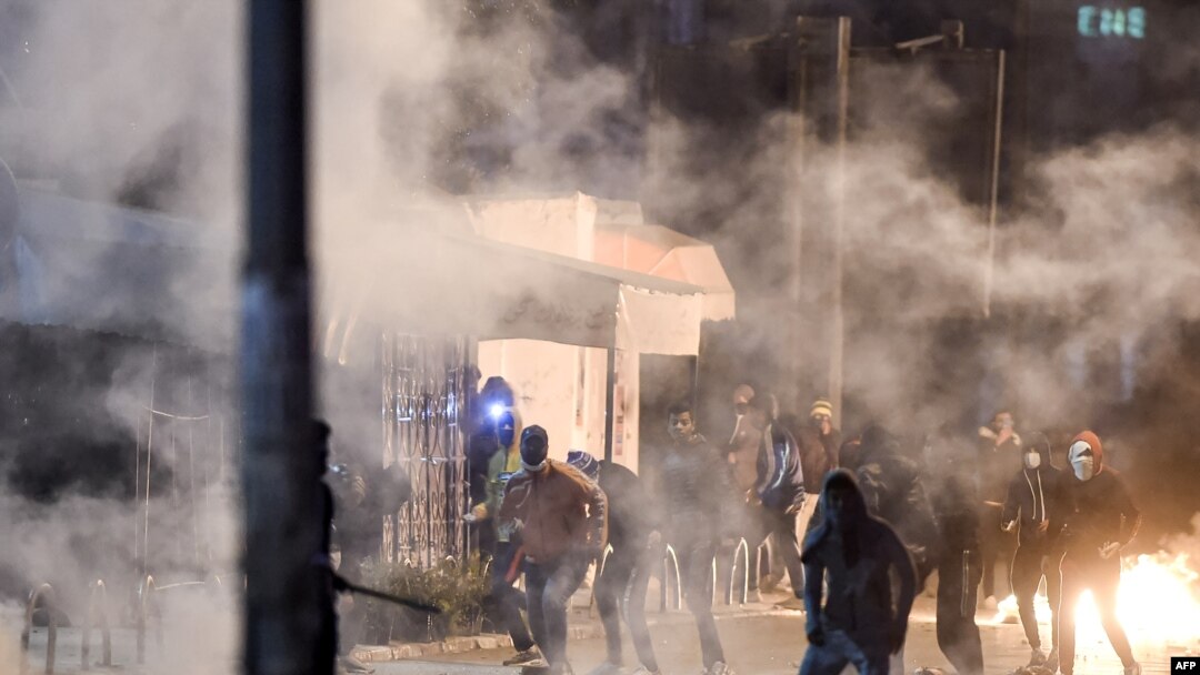 Demonstranti stoje usred dima dok blokiraju ulicu tokom sukoba sa snagama sigurnosti, Tunis 17. januara 2021.