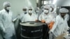 Iranian technicians remove a container of radioactive uranium for use at a uranium conversion facility in 2005. (file photo)