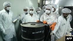 Iranian technicians remove a container of radioactive uranium for use at a uranium conversion facility in 2005. (file photo)