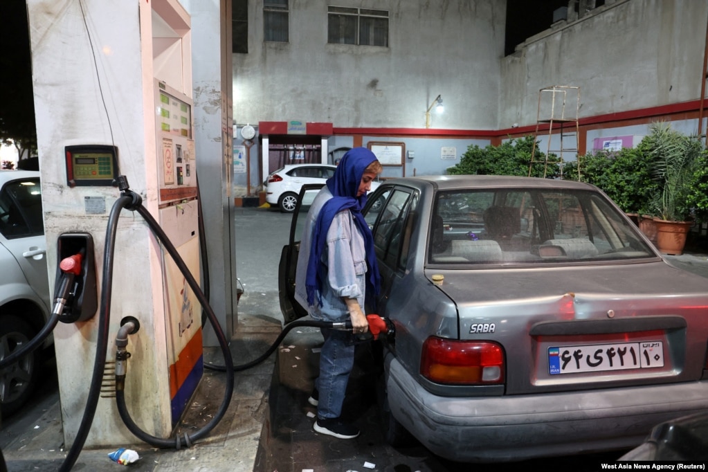 Një grua iraniane mbush makinën e saj me karburant ​​në Teheran mes frikës se një sulm izraelit mund të synojë infrastrukturën e industrisë së naftës të Iranit.