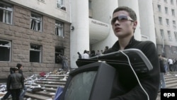 Moldova -- A young man carries a stolen TV, property of parliament during the anticommunist demonstration in Chisinau, 07Apr2009