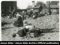 Țărani înfometați și obosiți așteaptă pe calea ferată din Harkov, în 1932.