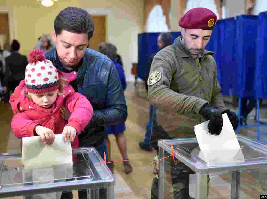 25 жовтня 2015 року. Люди голосують на одній з виборчих дільниць Києва під час місцевих виборів.&nbsp;Участь у місцевих виборах взяли майже 13,8 мільйона громадян, що склало 46,62% від загального числа виборців. Внутрішньо переміщені особи, а таких щонайменше 1,5 мільйона, права голосу були позбавлені