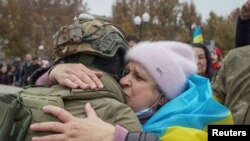 Herson ýaşaýjysy ukrain esgerini gujaklaýar.