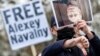 A supporter of Aleksei Navalny holds a picture of Russian President Vladimir Putin upside down in front of the Chancellery in Berlin earlier this year.