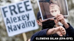 A supporter of Aleksei Navalny holds a picture of Russian President Vladimir Putin upside down in front of the Chancellery in Berlin earlier this year.