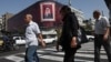 People walk past a billboard with an image of Iran's late Supreme Leader Ayatollah Ali Khamenei in Tehran on July 13. 