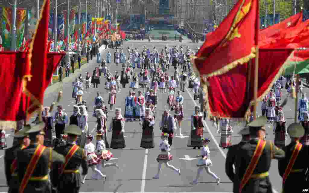 Belarusian youths wearing traditional national costumes take part in a Victory Day parade in Minsk.