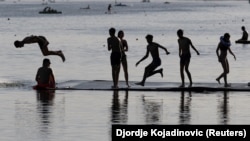 Tinejdžeri skaču u jezero na Adi kako bi se osvežili tokom toplotnog talasa u Beogradu, Srbija.
