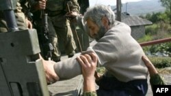 Russian troops in South Ossetia usher ethnic Georgian Tariel Basishvili into the back of a truck bound for Tbilisi on September 5.