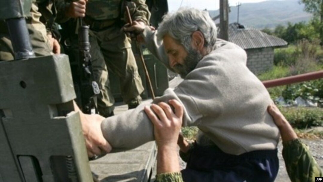 Russian troops in South Ossetia usher ethnic Georgian Tariel Basishvili into the back of a truck bound for Tbilisi on September 5.