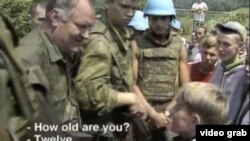 A screen grab of Bosnian Serb General Ratko Mladic meeting a Bosnian Muslim boy shortly before the 1995 massacre in Srebrenica.