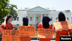 Activists wearing orange jumpsuits mark the 100th day of a prisoners' hunger strike at Guantanamo Bay during a protest in May in front of the White House in Washington, D.C.