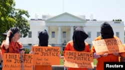 Активисты в оранжевых комбинезонах перед Белым домом во время акции протеста, посвященной голодовке заключенных Гуантанамо, 17 мая 2013 года.