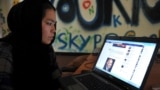 An Afghan woman browses Facebook at an Internet cafe in Kabul before the Taliban takeover in 2021. 