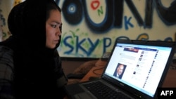An Afghan woman browses Facebook at an Internet cafe in Kabul before the Taliban takeover in 2021. 