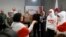 Exiled Belarusian opposition leader Svetlana Tikhanovskaya (3rdR) looks on as she stands next to members of the Belarusian Volny Chor (R) performing during a press conference with freed political prisoners, among them Belsat journalist Iryna Slaunikava (2