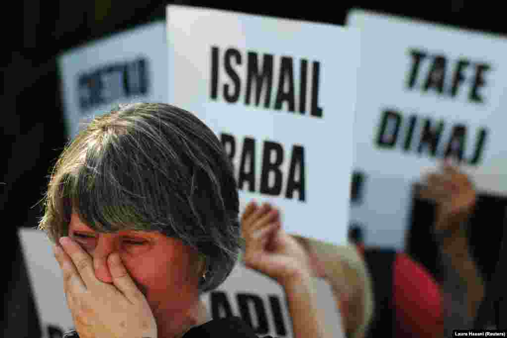 A woman cries as people hold the names of missing persons as they marked the International Day of the Disappeared, in Pristina, Kosovo, on August 30. (Reuters/Laura Hasani)
