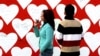 Turkey -- A couple seen in front of the giant billboard with empty hearts for filling with love messages during St. Valentine's Day in Istanbul, 14Feb2006