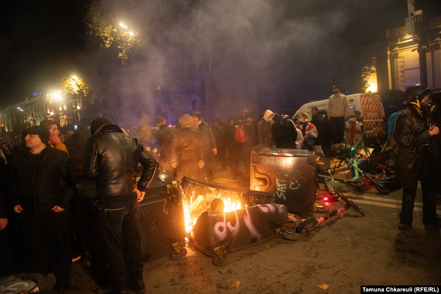 Protestuesit afër një barrikade të djegur.