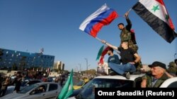 АҚШ пен одақтастарының Сирияға қарсы әуе соққысына наразылық білдірушілер Сирия мен Ресей туларын ұстап тұр. Дамаск, 14 сәуір 2018 жыл
