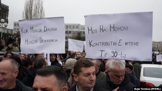 Protestuesit mbajnë pankarta me mbishkrimet "Kur mungon dialogu, mungon demokracia" dhe "Mos na mohoni kontributin e viteve të '90-ta", gjatë protestës së SBASHK-ut në Prishtinë, 4 dhjetor.