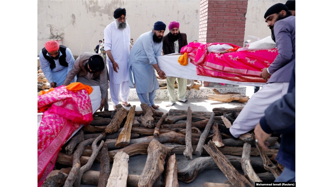 Afghan Sikh men carry the coffins of victims of an attack on a Sikh religious complex before they light a funeral pyre in Kabul on March 26, 2020. Twenty-five worshippers were killed.