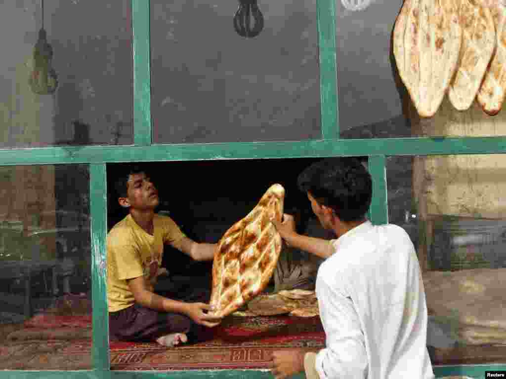 A man prepares bread in his bakery for sale in Kabul on August 11. Photo by Mohammad Ismail for Reuters