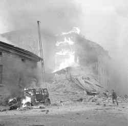 Разрушенные здания и горящий автомобиль в Хельсинки после авианалета в день начала войны.