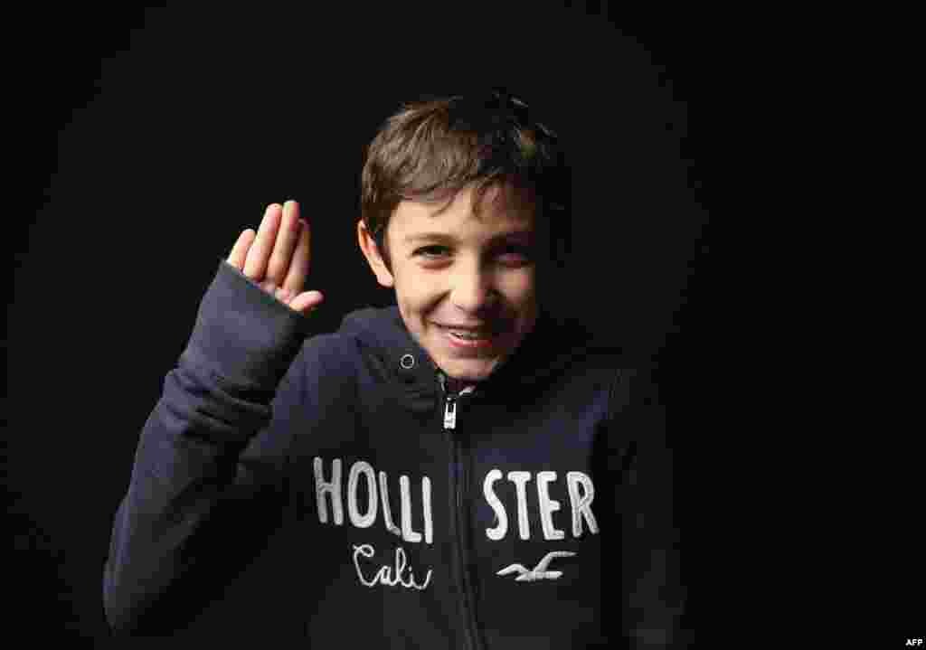 Fifth-grader Theodore Poncer, 10, born in France, holds his hand as he did for the oath of allegiance. His mother is a marketing consultant.