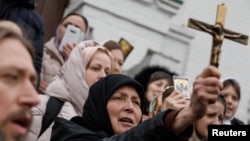Believers pray while they block an entrance to a church on the compound of the Kyiv-Pechersk Lavra monastery in Kyiv on March 31.