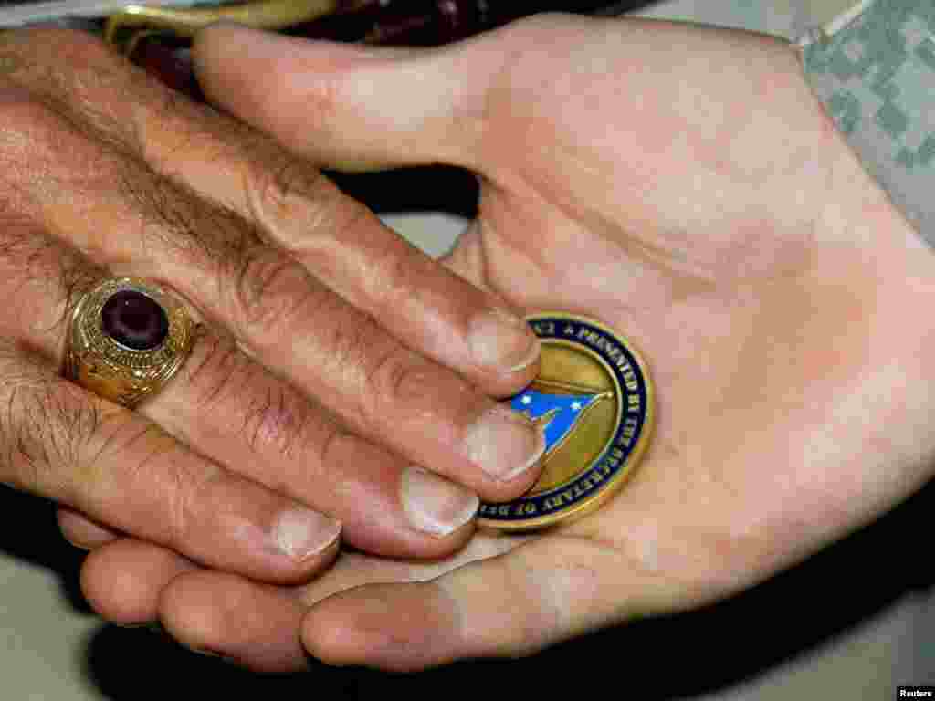 U.S. Defense Secretary Leon Panetta places a "challenge coin" in the palm of a U.S. soldier during a ceremony where he presented more than 150 such coins to troops at Camp Victory in Baghdad.Photo by Paul J. Richards for Reuters