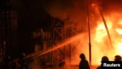 Пожарникари работят в топлоелектрическата централа в Харков, повредена от руски ракетен удар.