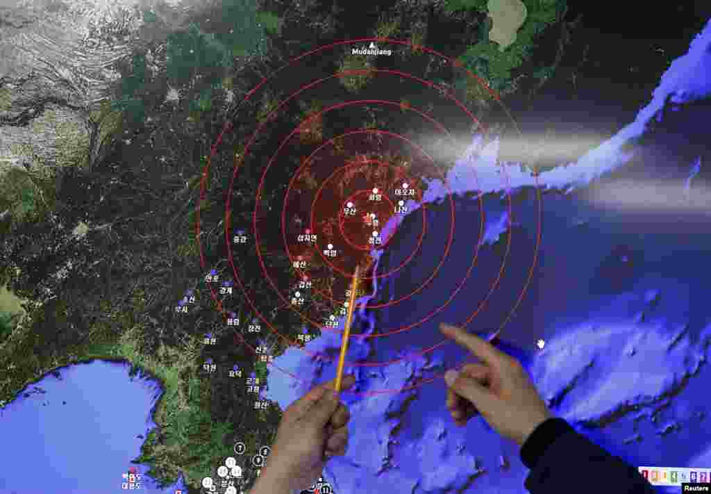 Сотрудник метеорологической администрации в Южной Корее показывает на картинку сейсмических колебаний, предположительно, вызванных тестом в КНДР