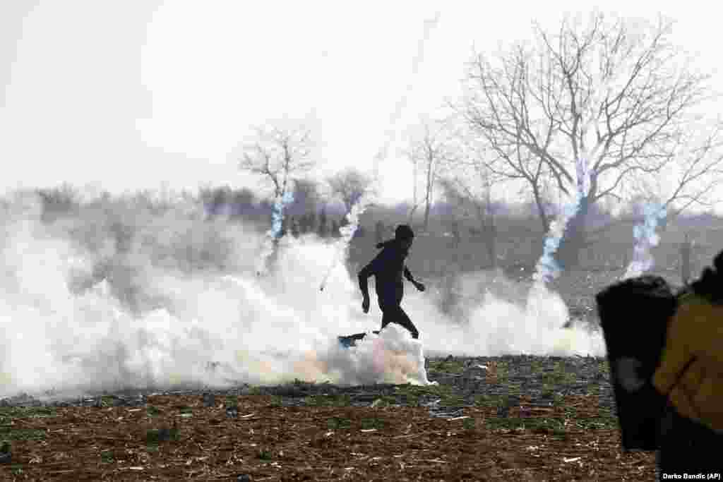 A migrant runs to avoid tear gas fired by Greek police during clashes near the Pazarkule crossing near Edirne, at the Turkish-Greek border, on March 2.