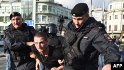 Russian security detain a man following a rally calling for fair elections in central Moscow in August last yeat. 