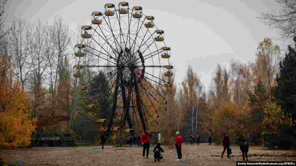 Наразі Чорнобильська зона відчуження перетворюється на одне з найпопулярніших туристичних місць в Україні. На фото &ndash; іноземні туристи біля оглядового колеса &laquo;мертвого&raquo; міста Прип&#39;ять