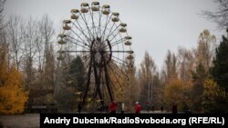 Іноземні туристи біля оглядового колеса у місті Прип'ять