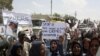 Residents of Camp Ashraf demonstrate in front of reporters touring in a bus on April 9, a day after their clashes with the Iraqi security forces.