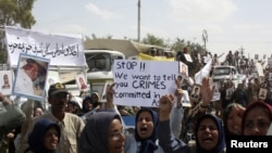 Residents of Camp Ashraf demonstrate in front of reporters touring in a bus on April 9, a day after their clashes with the Iraqi security forces.