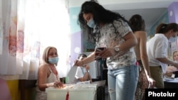 Armenia - A woman casts a ballot at a polling station in Yerevan during parliamentary elections, June 20, 2021.