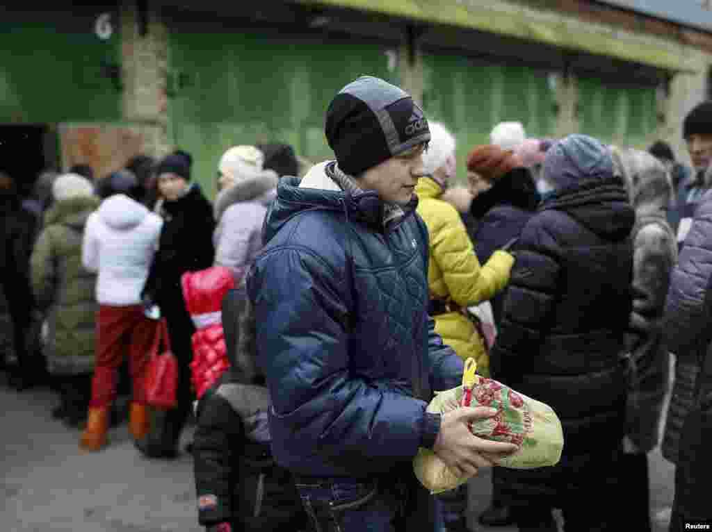 Біженець зі Східної України несе пакет з їжею з пункту волонтерської допомоги у Слов&#39;янську, 7 лютого 2015 року
