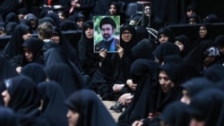 Supporters hold a banner of Iranian Supreme Leader Mojtaba Khamenei, who has not been seen in public since February 28.