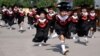 China -- Children in gowns and mortarboards run with smiles during their kindergarten graduation ceremony in a kindergarten in Handan, Hebei province, June 20, 2017