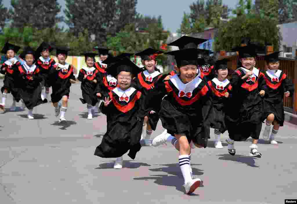 Children in gowns and mortarboards are all smiles during their kindergarten graduation ceremony in Handan, Hebei Province, China. (Reuters/China Daily)