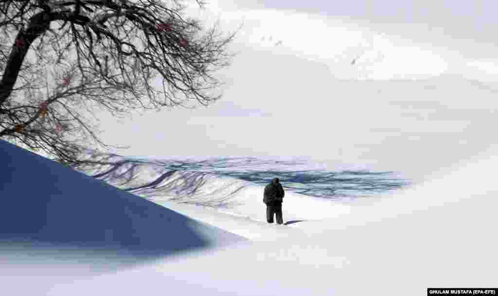 A man makes his way through snow in Ghazni, Afghanistan. Afghanistan is experiencing harsh winters with temperatures falling well below freezing in many parts of the country. (epa-EFE/Ghulam Mustafa)