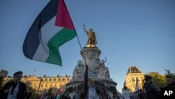 Një grua mban një flamur palestinez gjatë një tubimi propalestinez në sheshin e Republikës në Paris, 17 shtator 2025.